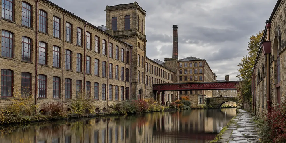 Yorkshire sandstone mill buildings beside a canal in the Bradford district